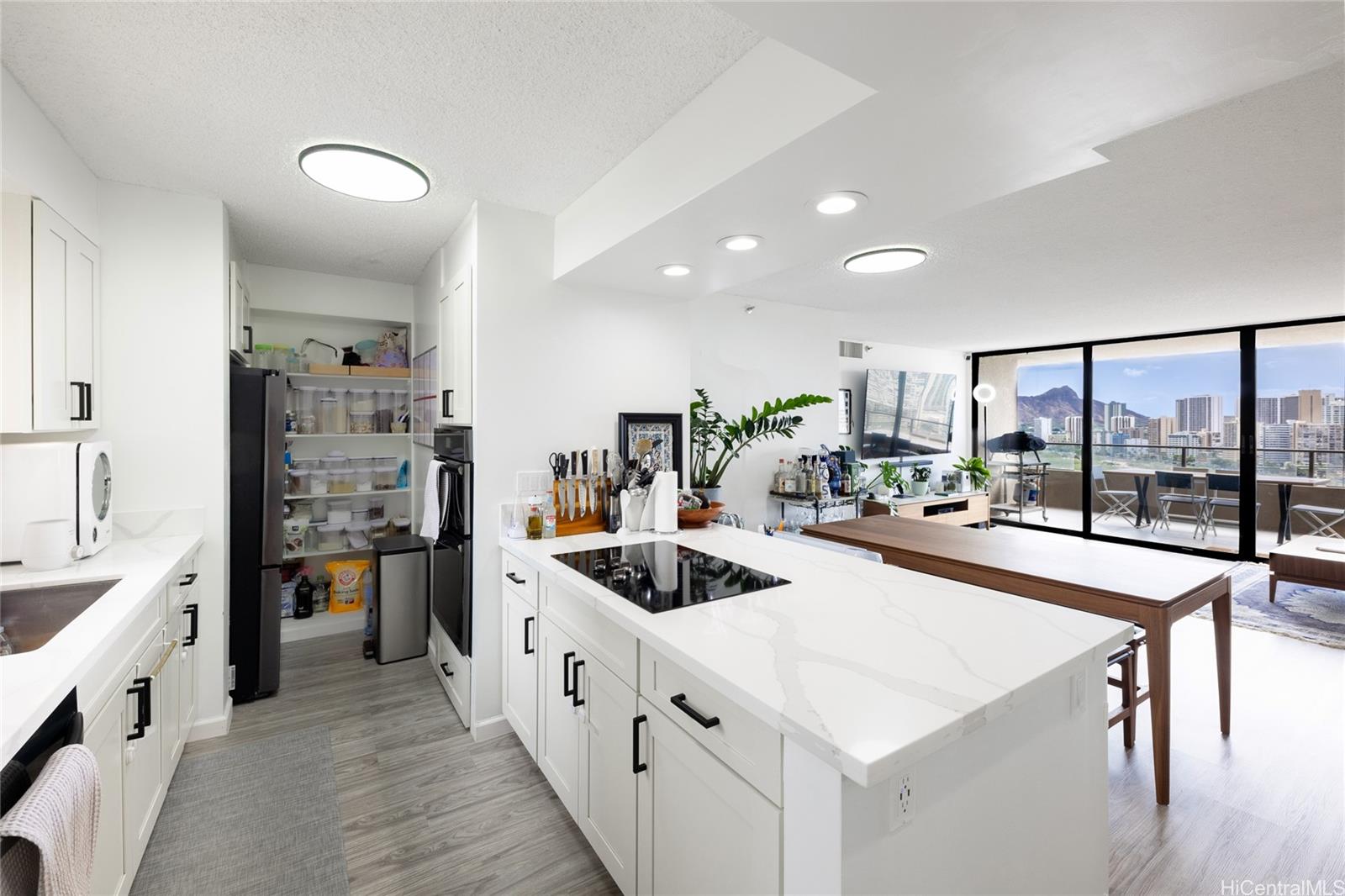 a large white kitchen with a large window and stainless steel appliances