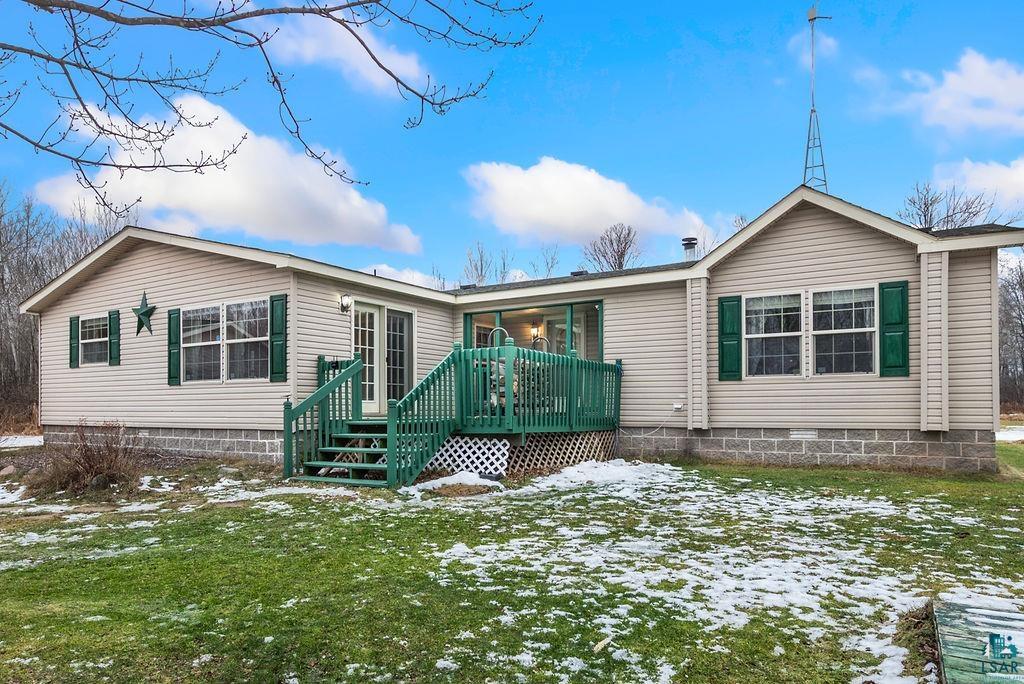 Snow covered property featuring a lawn and a wooden deck