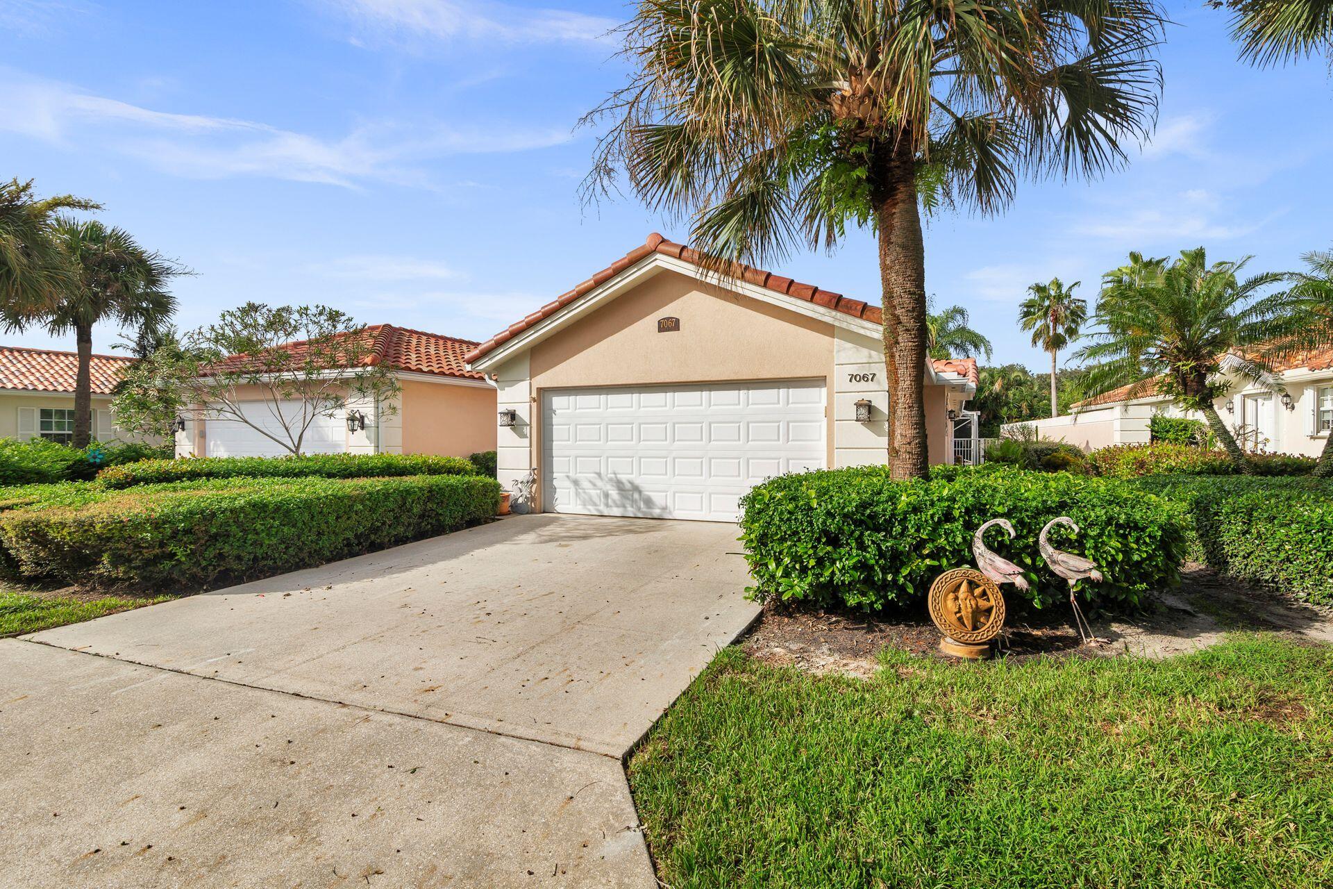 a front view of a house with a yard and potted plants