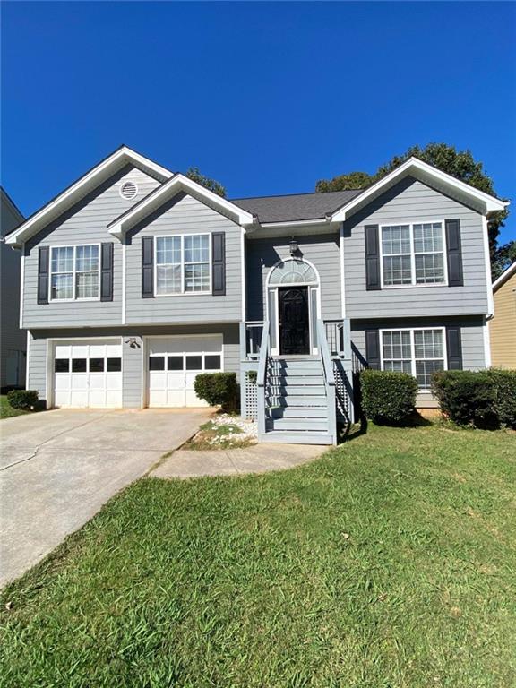 a front view of a house with a yard and garage