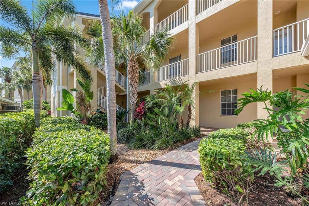 a view of a multi story yard with plants and palm trees