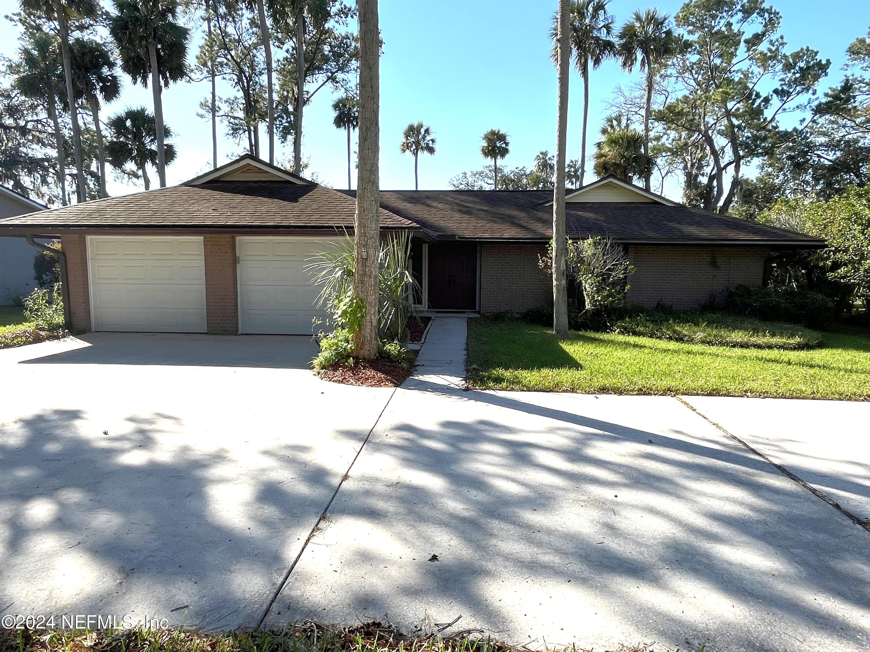 a front view of a house with a yard and a garage