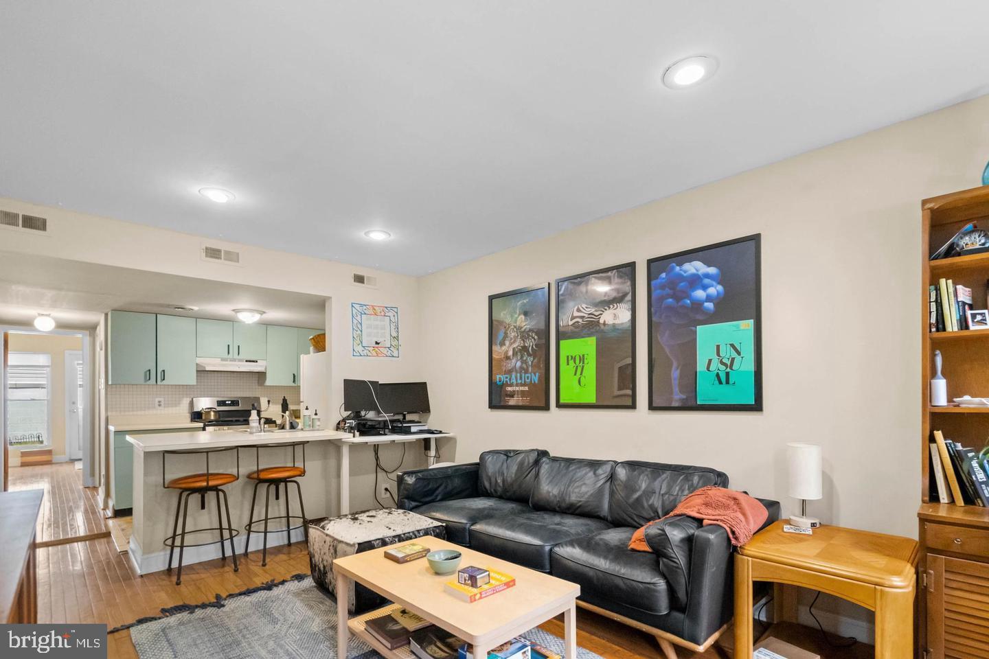 a living room with furniture and a view of kitchen appliance