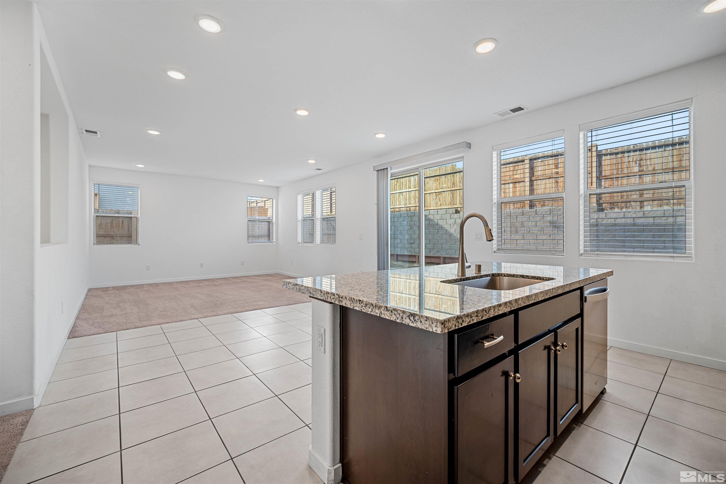 a kitchen with granite countertop a sink and a stove