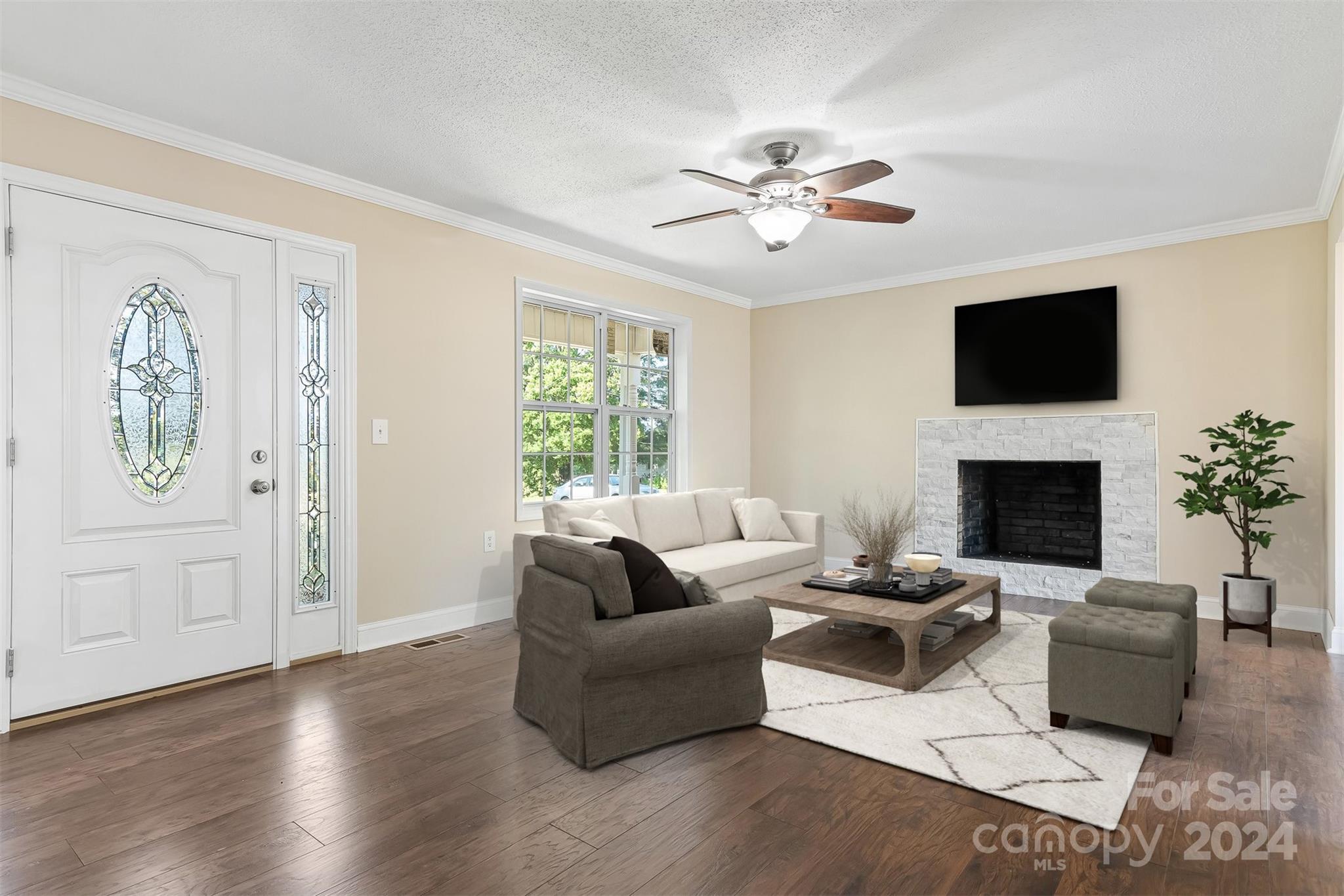 a living room with furniture a flat screen tv and a window