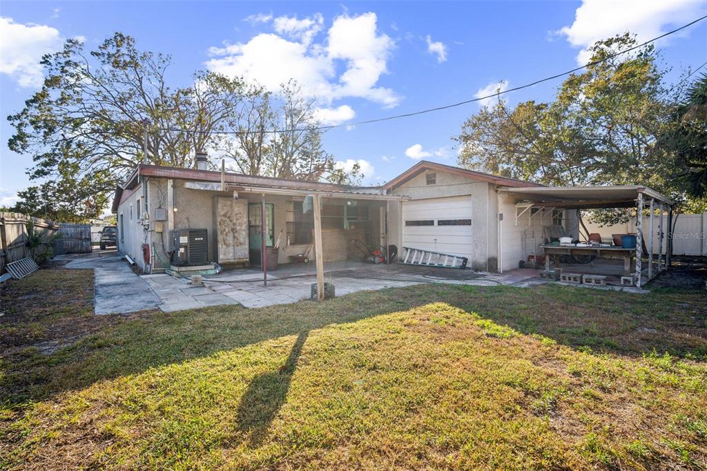 a view of a house with a yard and large tree