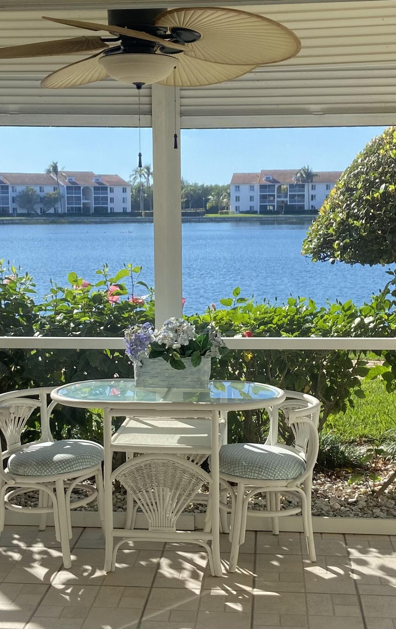 a table and chairs sitting on a patio near a lake