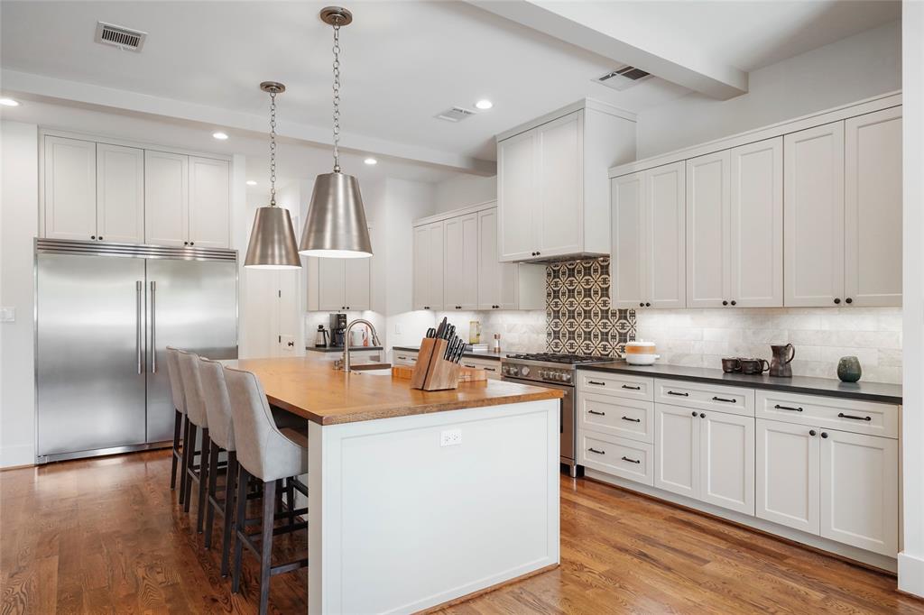 a kitchen with kitchen island granite countertop a sink a counter space appliances and cabinets