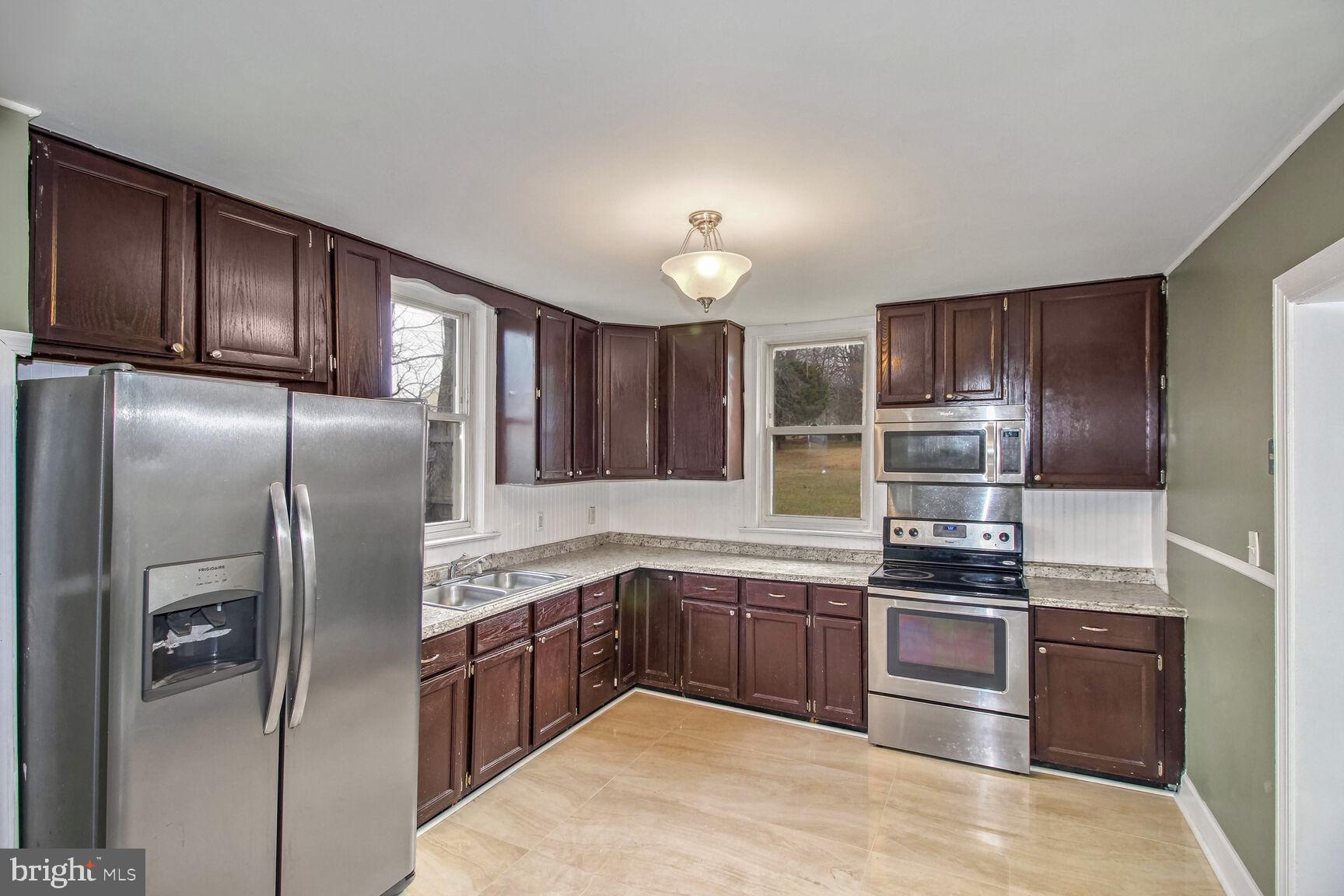 a kitchen with stainless steel appliances granite countertop a refrigerator and a stove top oven