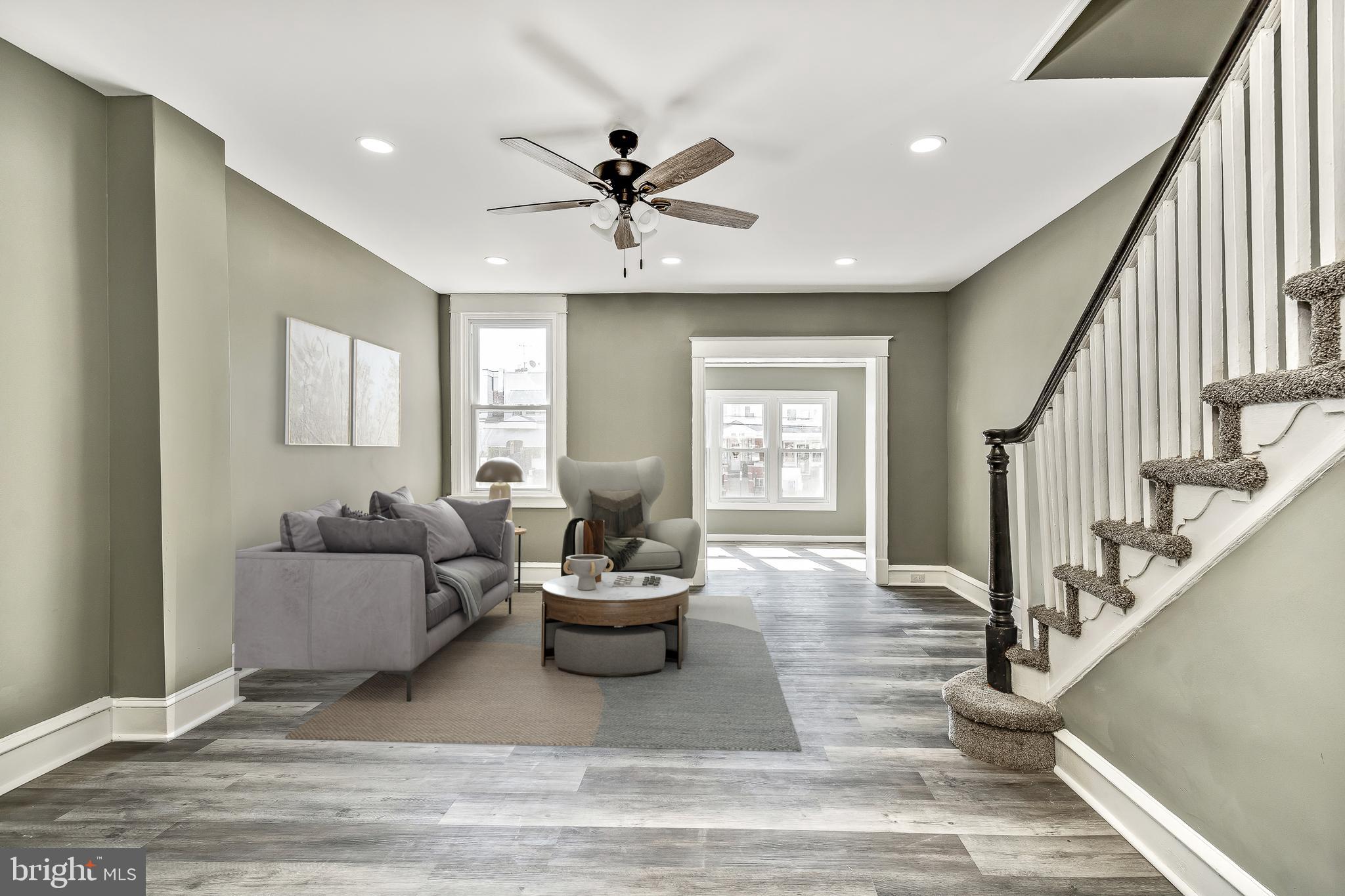 a living room with furniture and a wooden floor