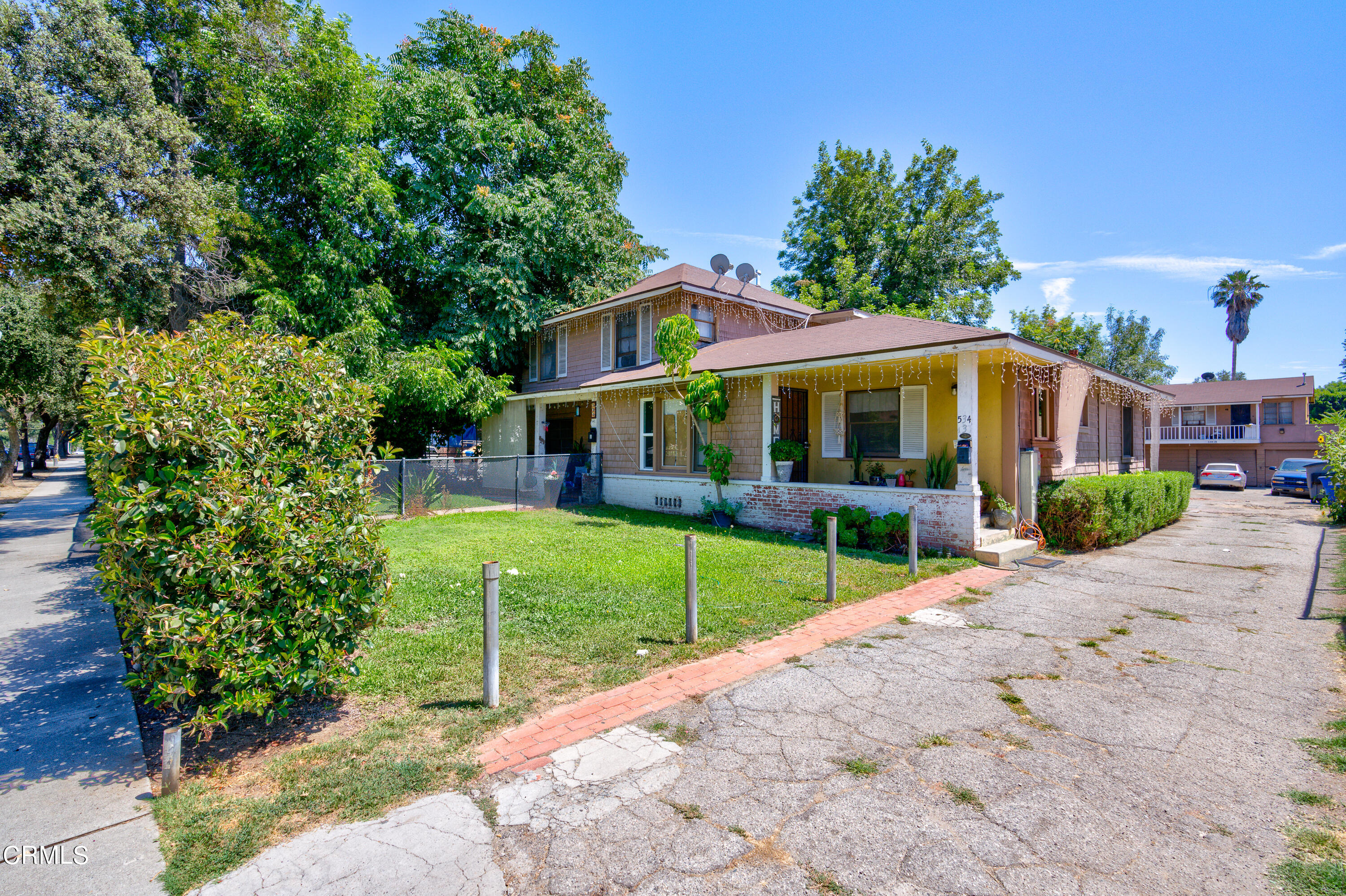 a view of a house with a yard and potted plants