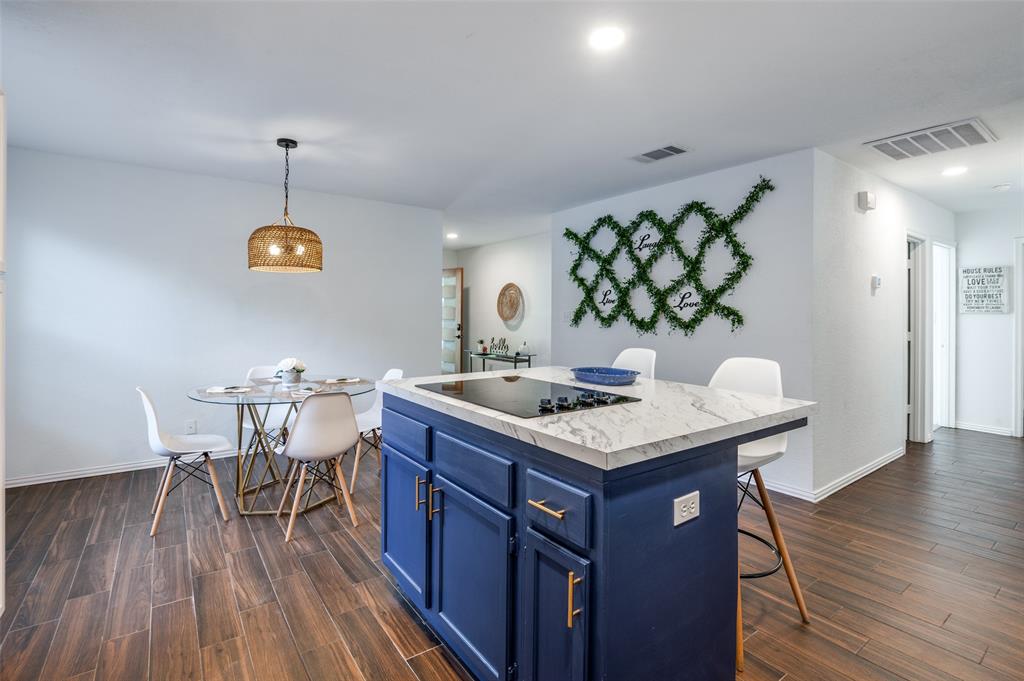 a kitchen with a table chairs and wooden floor