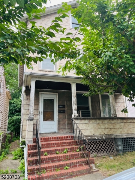 a front view of a house with a tree