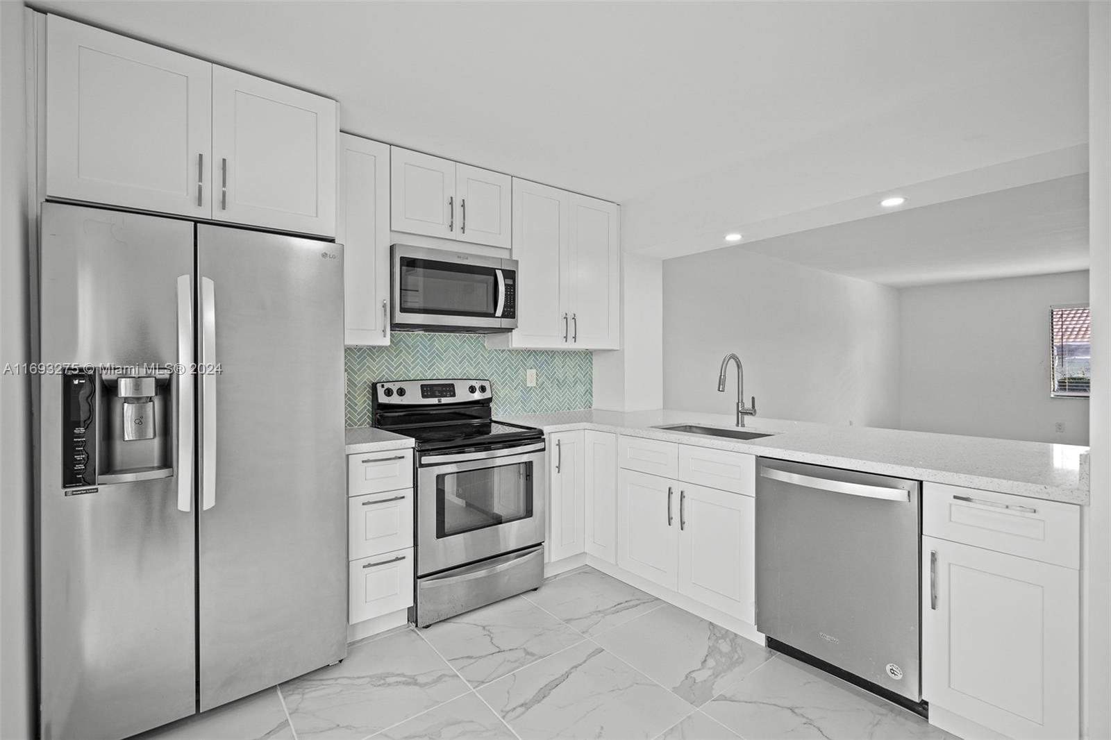 a kitchen with cabinets stainless steel appliances and a counter space