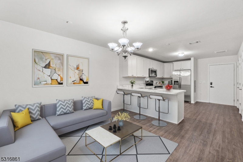 a living room with kitchen island furniture and a chandelier