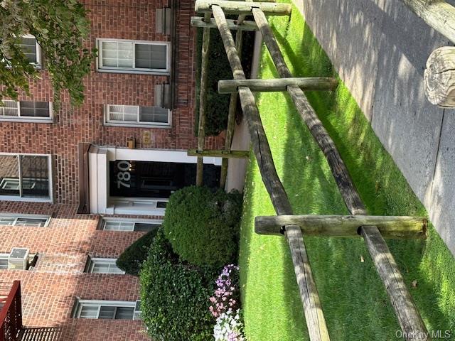 View of exterior entry featuring cooling unit and a yard