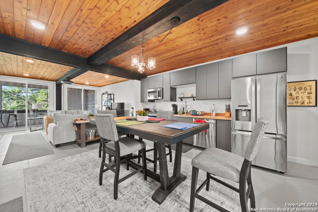 a kitchen with a table chairs refrigerator and cabinets