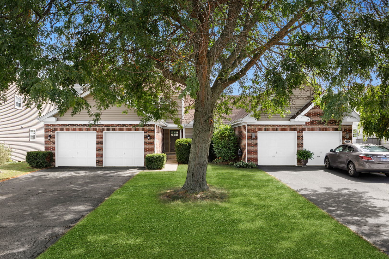 a view of a house with a yard and large trees