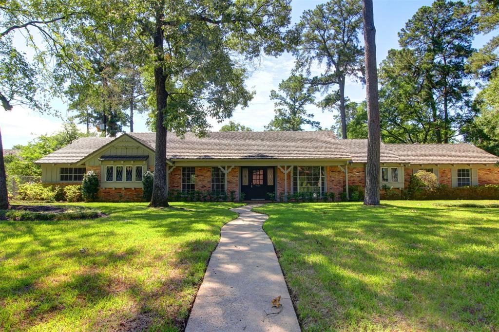 a front view of a house with yard and green space