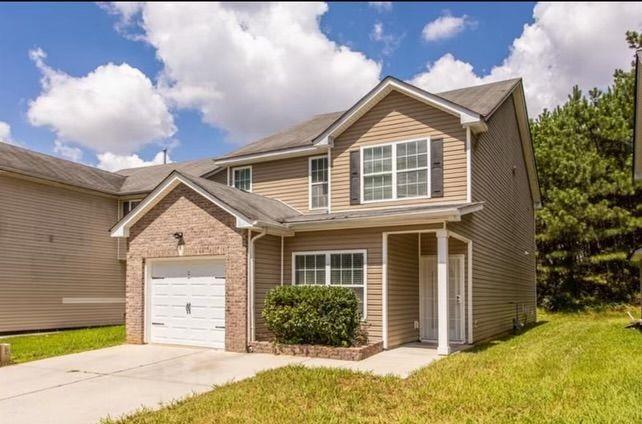 a front view of a house with a yard