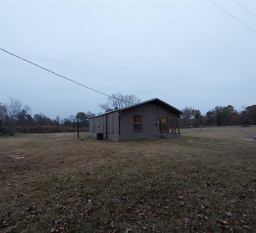 a view of a barn house in a field with large trees