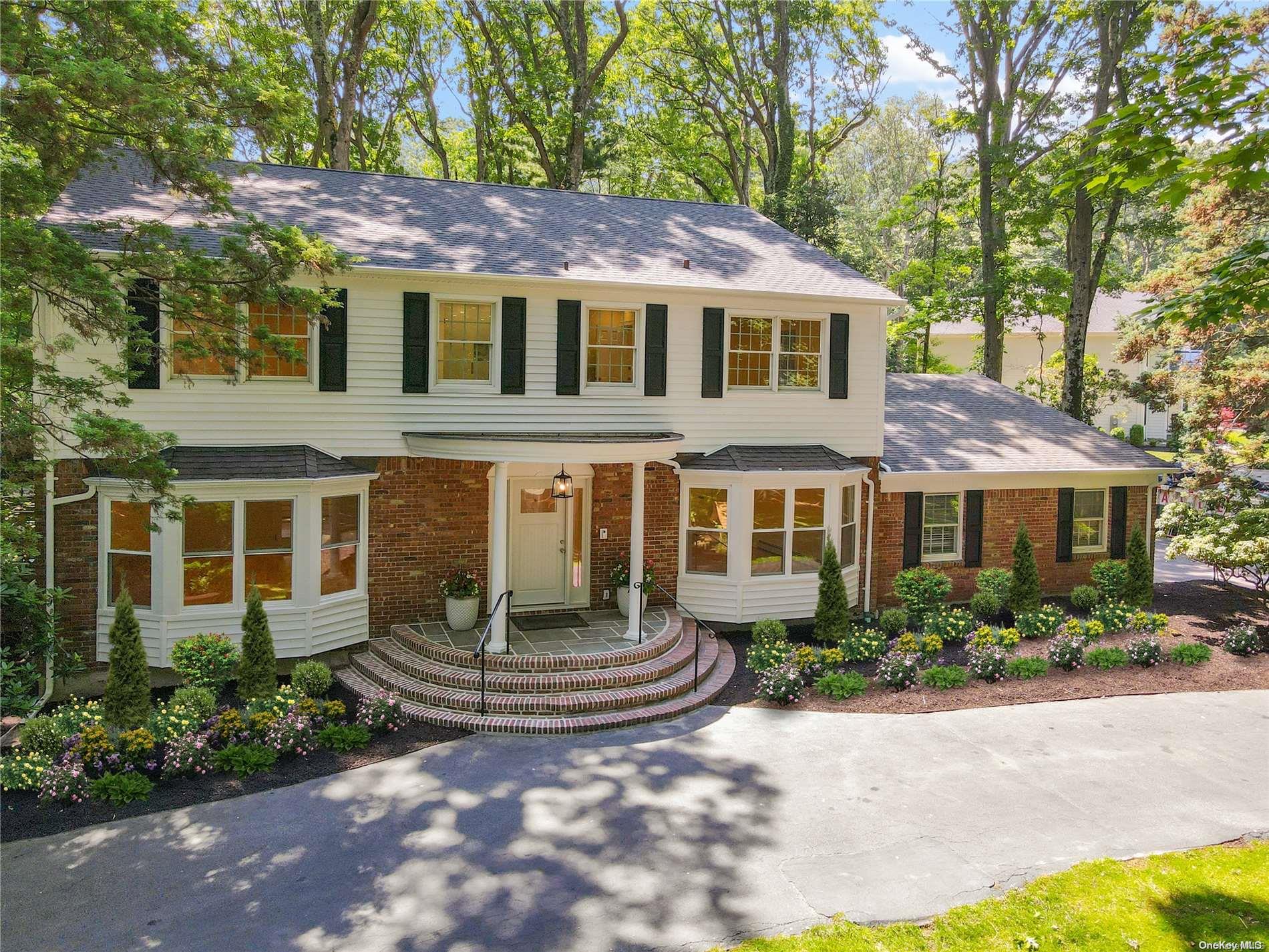 a front view of a house with a garden and plants