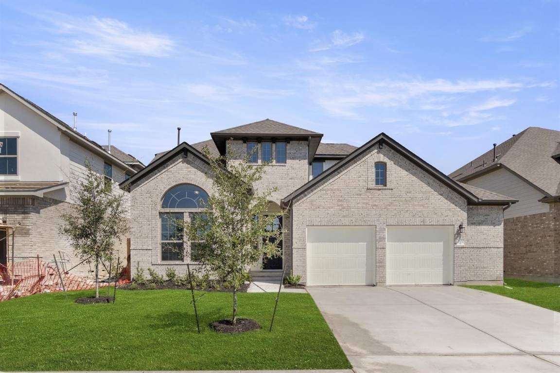 a front view of a house with a garden and yard