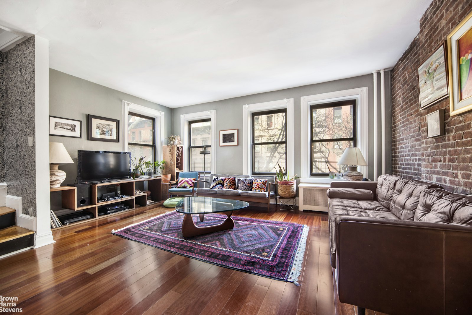 a living room with furniture a flat screen tv and a large window