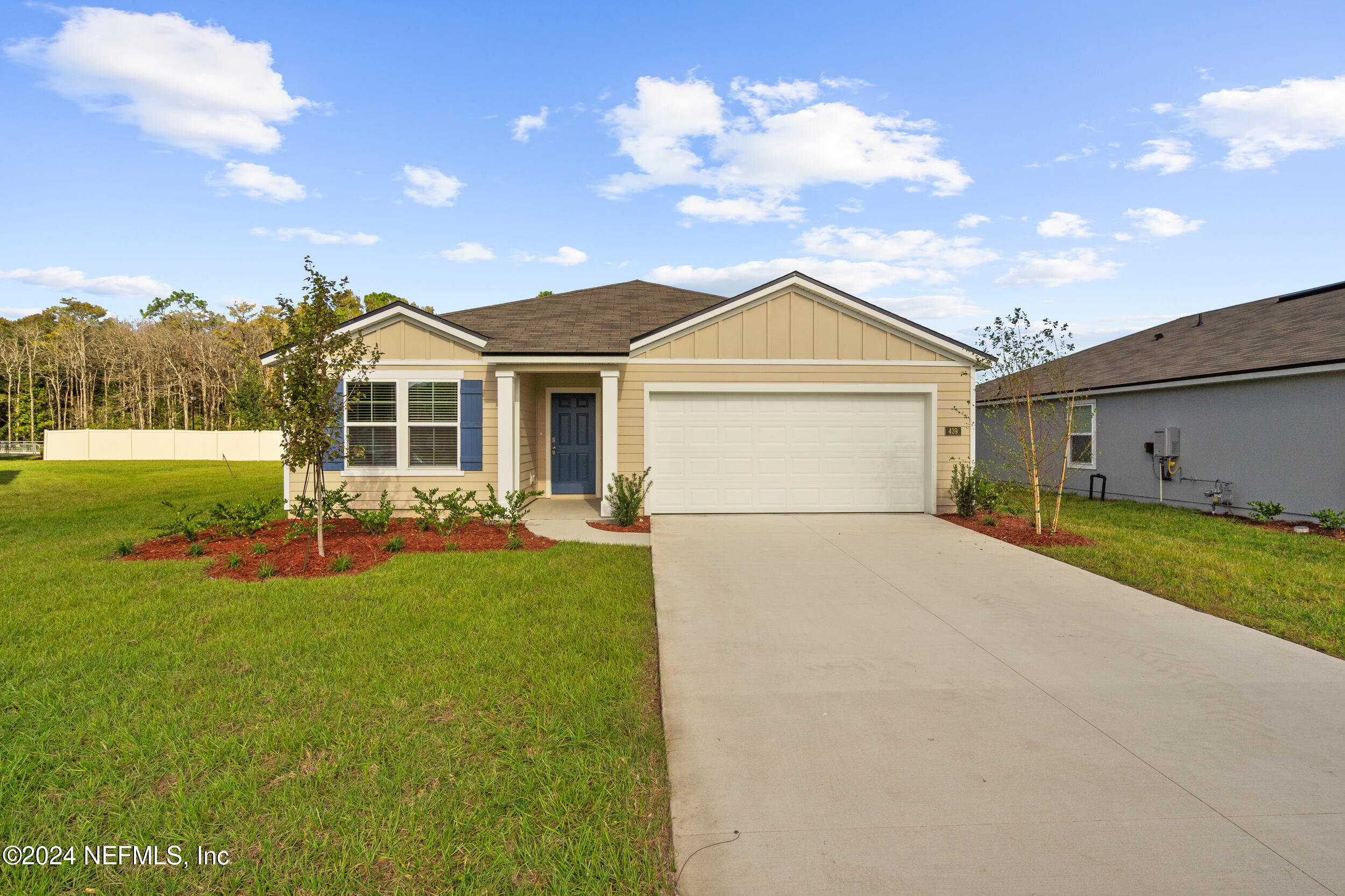 a front view of a house with a garden and yard