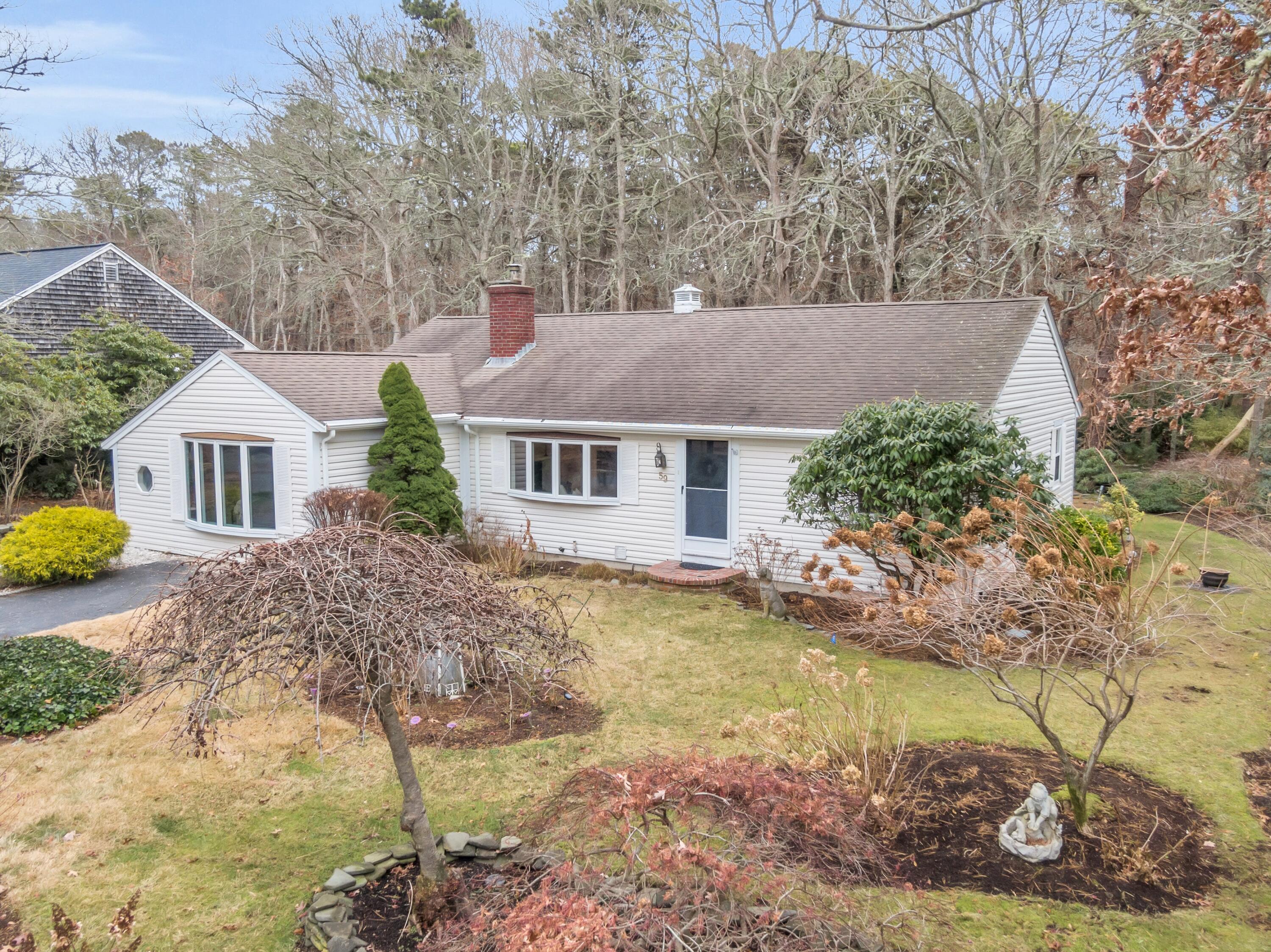 a front view of house with yard and trees in the background