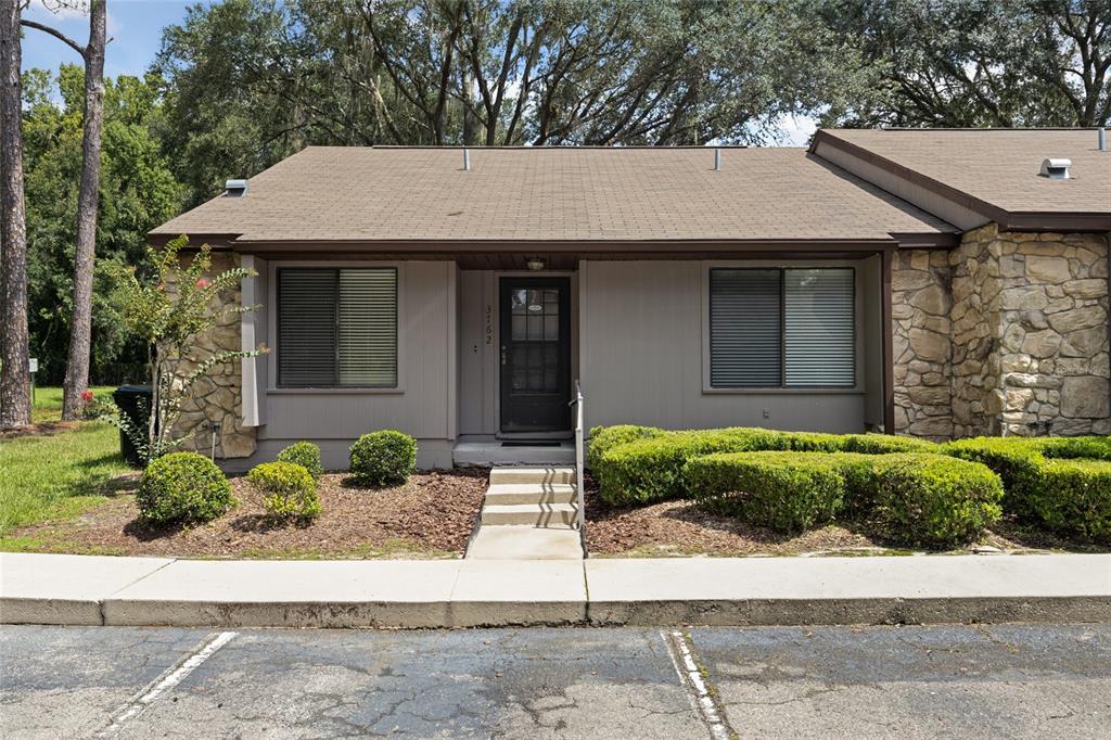 a front view of a house with a garden