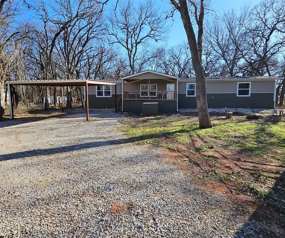 a view of a yard in front of a house with large trees