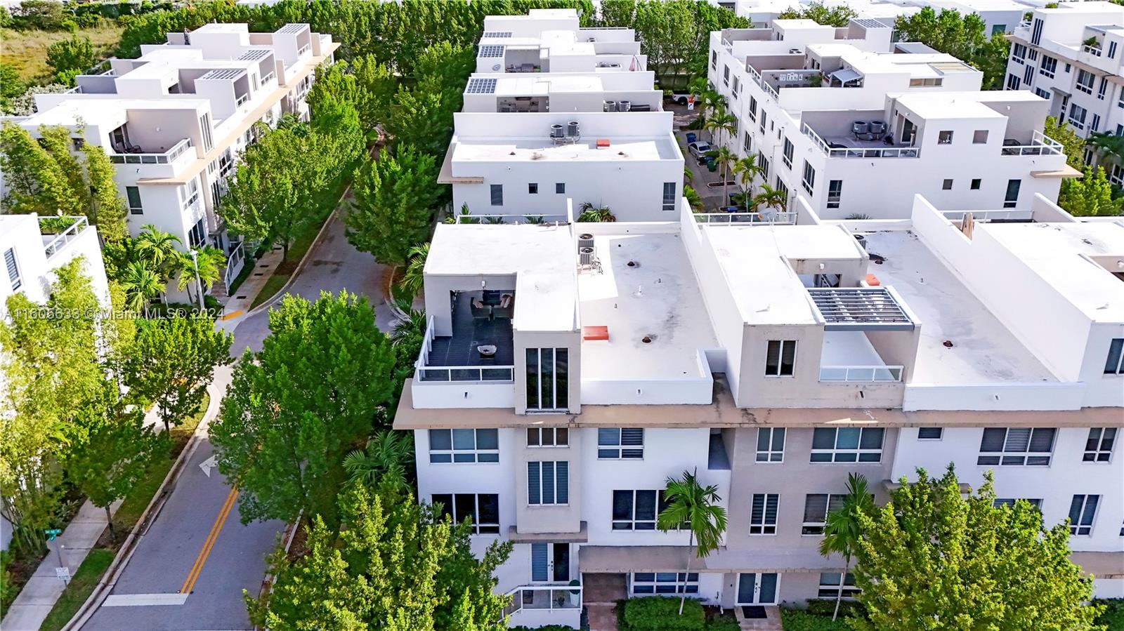 an aerial view of residential houses with plants and trees all around