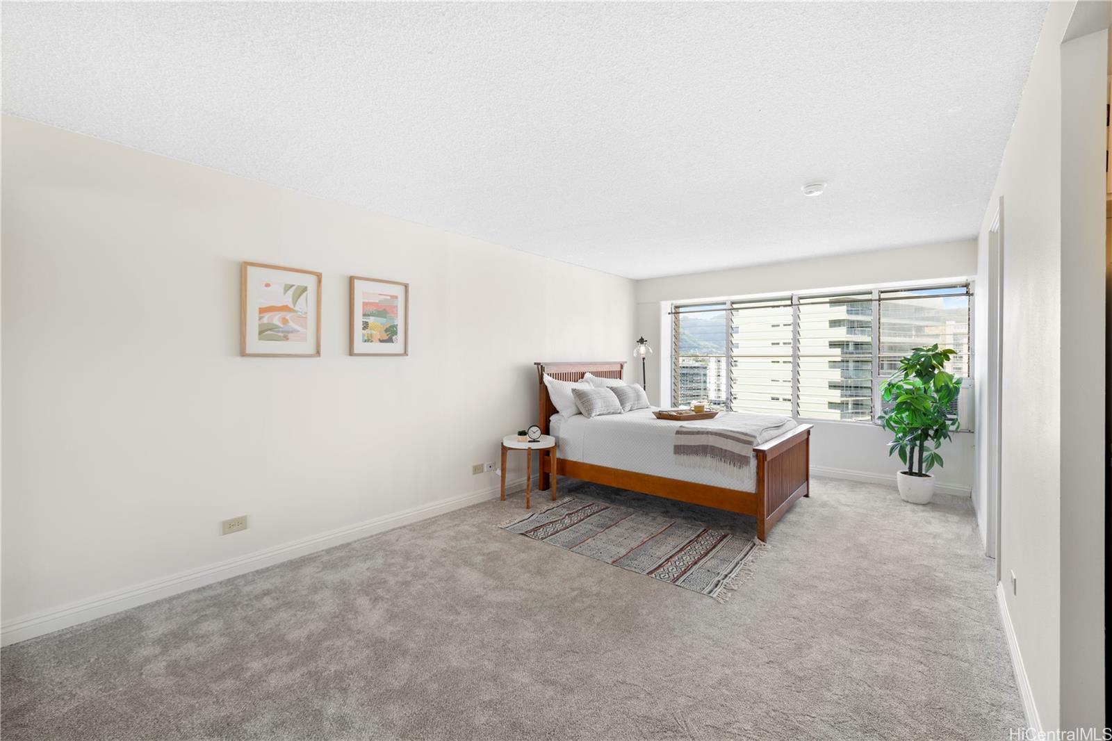 a bedroom with a bed and a potted plant