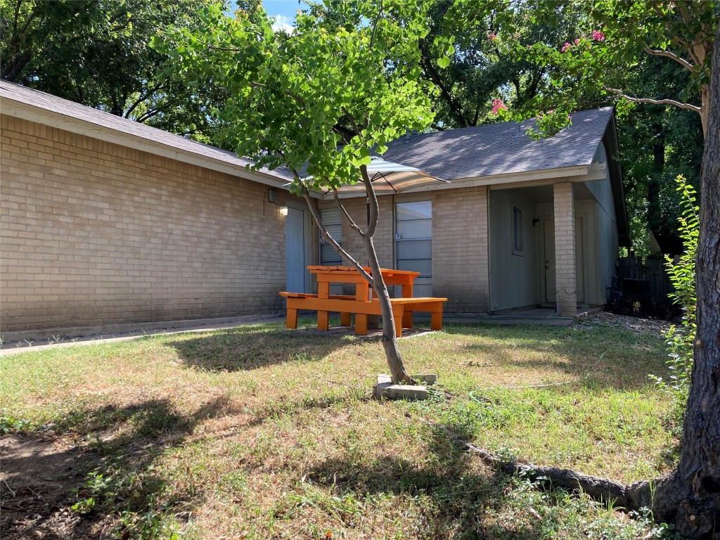 a backyard of a house with barbeque oven table and chairs