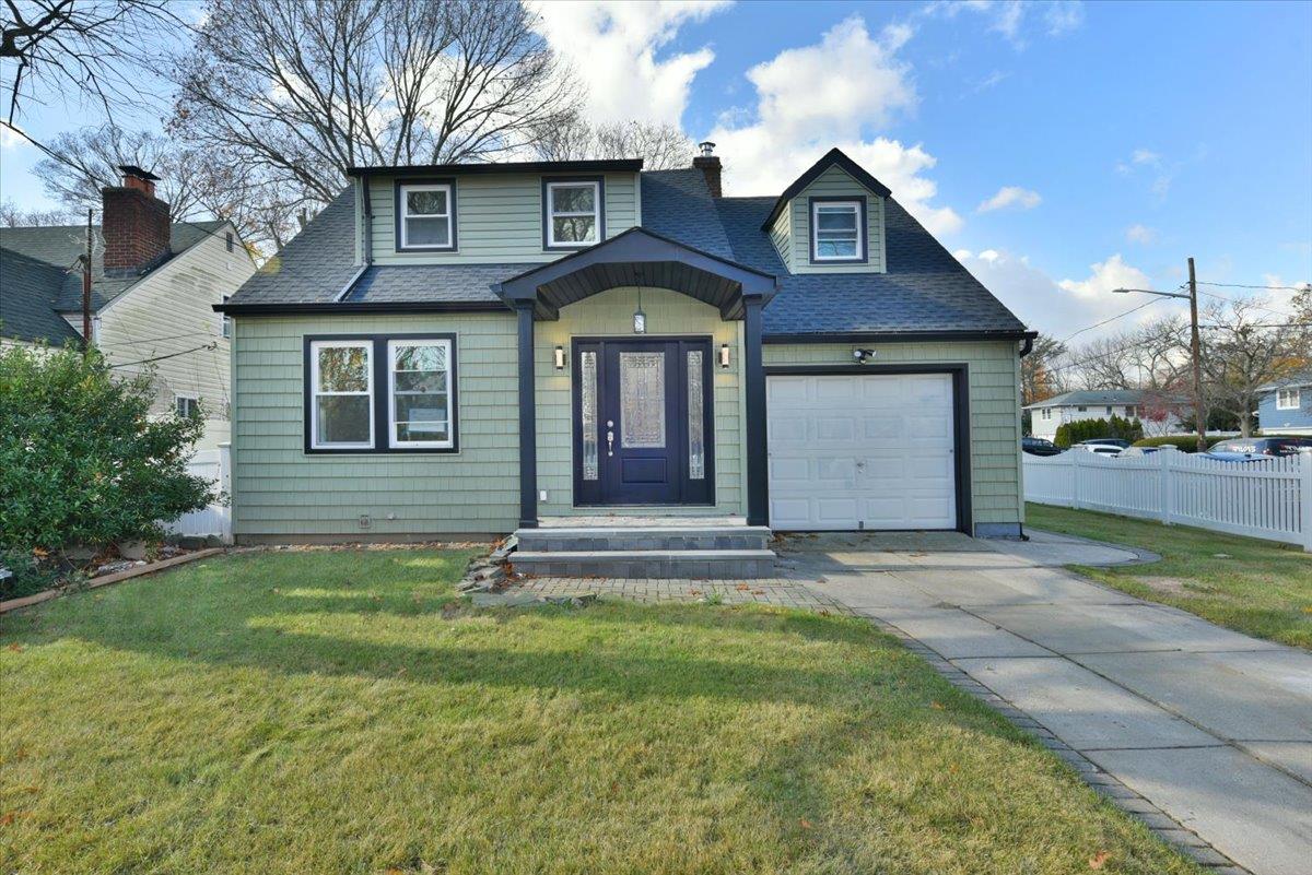 View of front of house with a front lawn and a garage