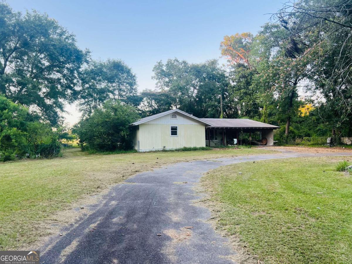 a front view of a house with a yard and trees