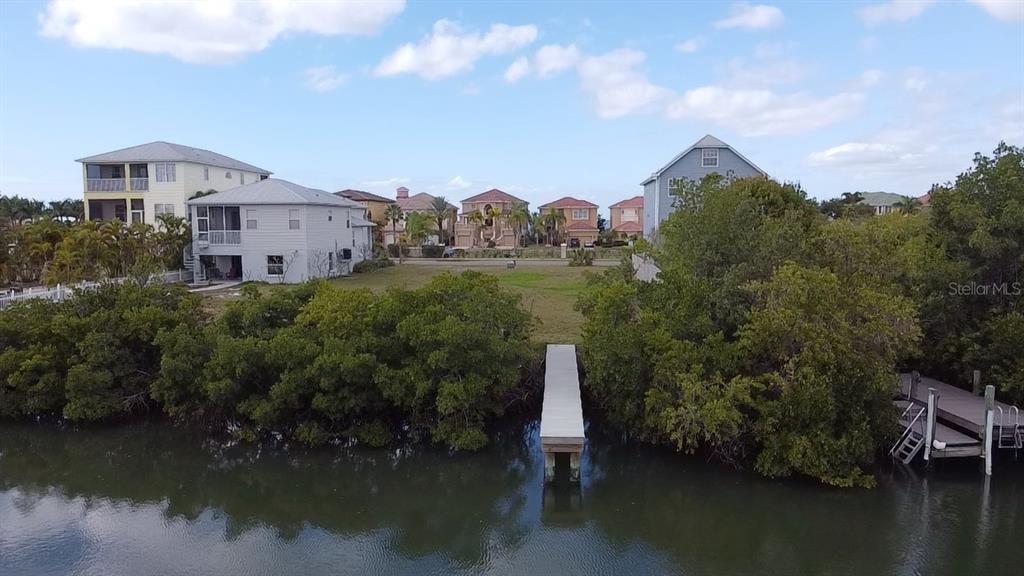 a view of a house with a yard and a pond