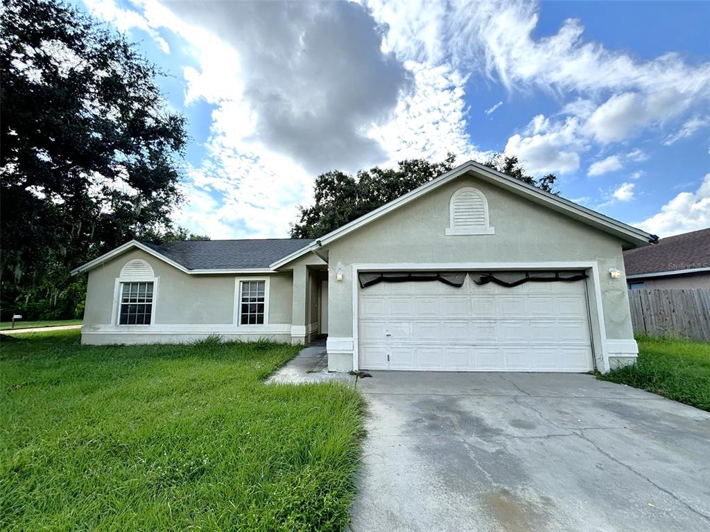 a view of a house with a yard and garage