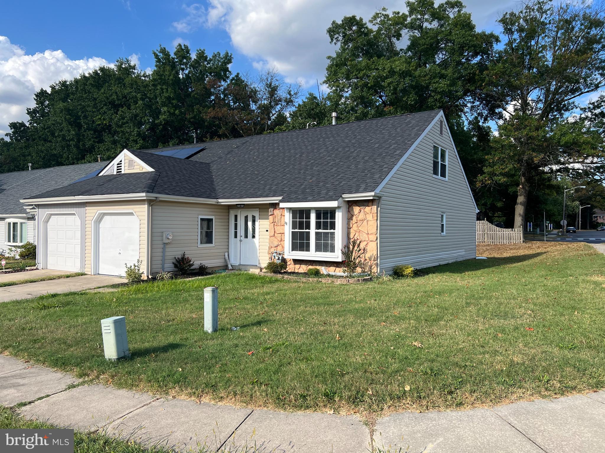 a front view of a house with a yard and trees