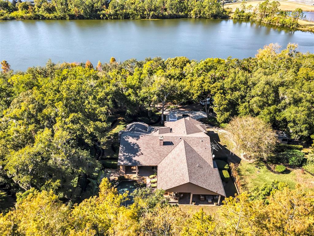 an aerial view of a house with a yard and lake view