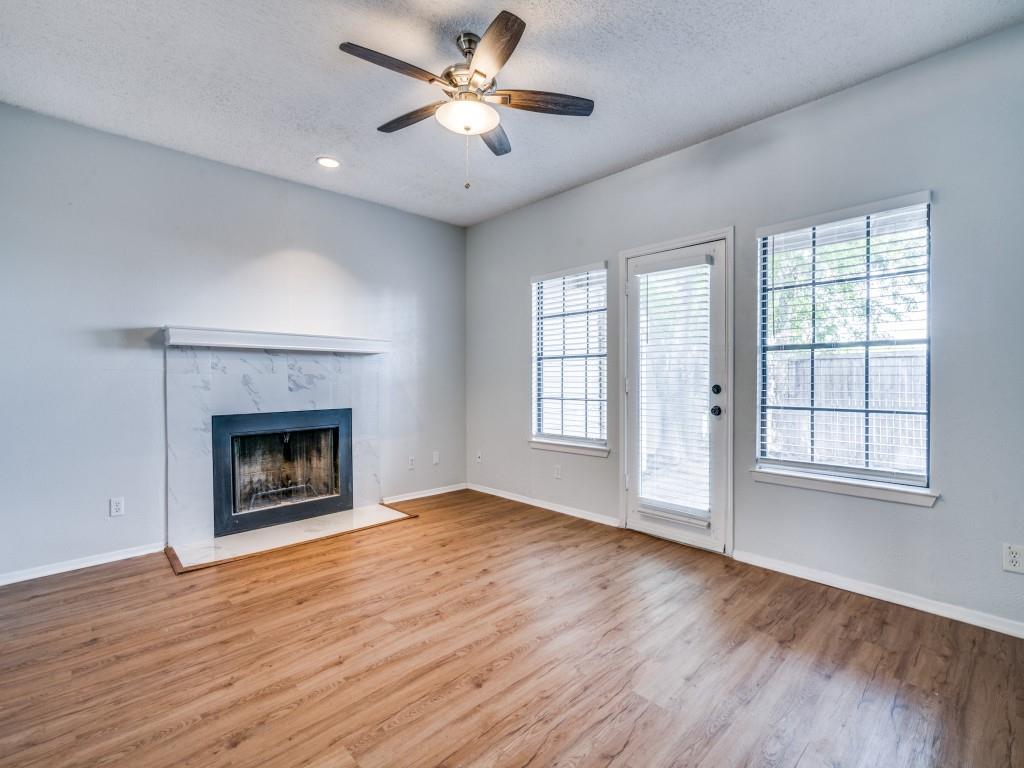 wooden floor fireplace and windows in an empty room