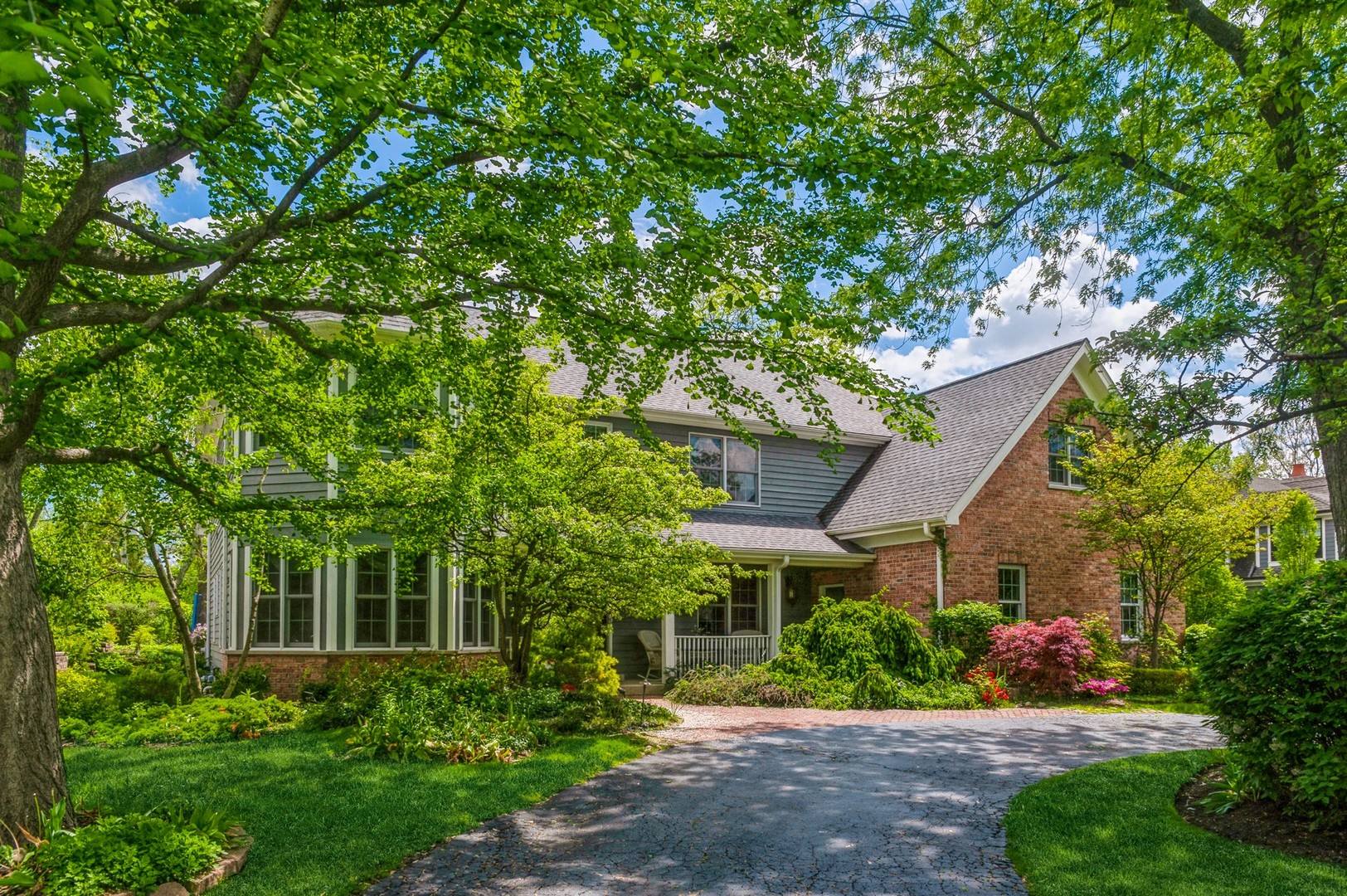 a front view of a house with a yard and potted plants