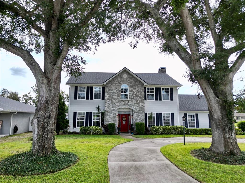 a front view of a house with a yard and trees