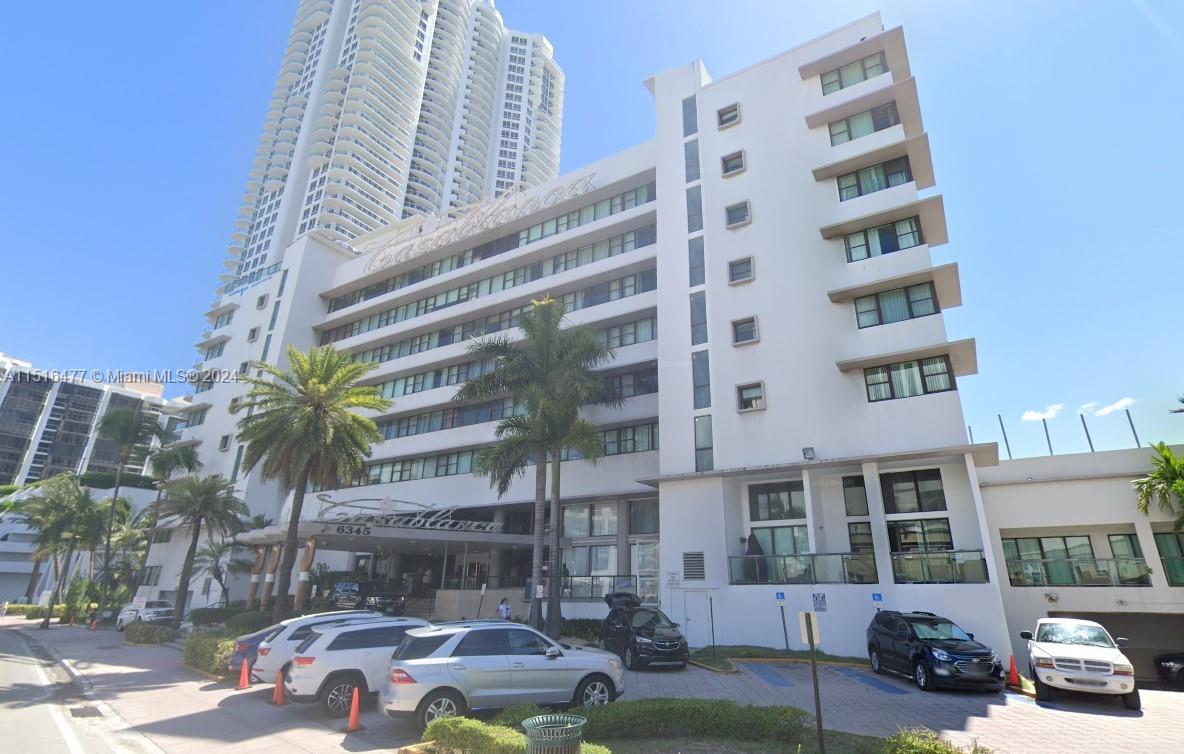 a front view of a building with street view and trees