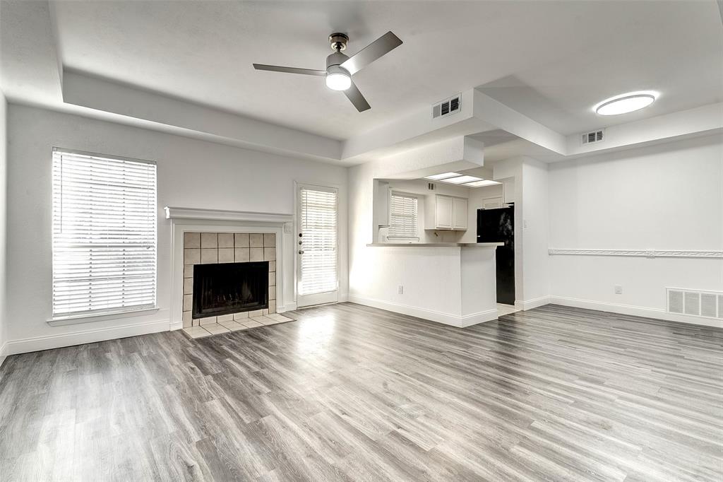 living room featuring a tiled fireplace, ceiling fan, and light hardwood / wood-style floors