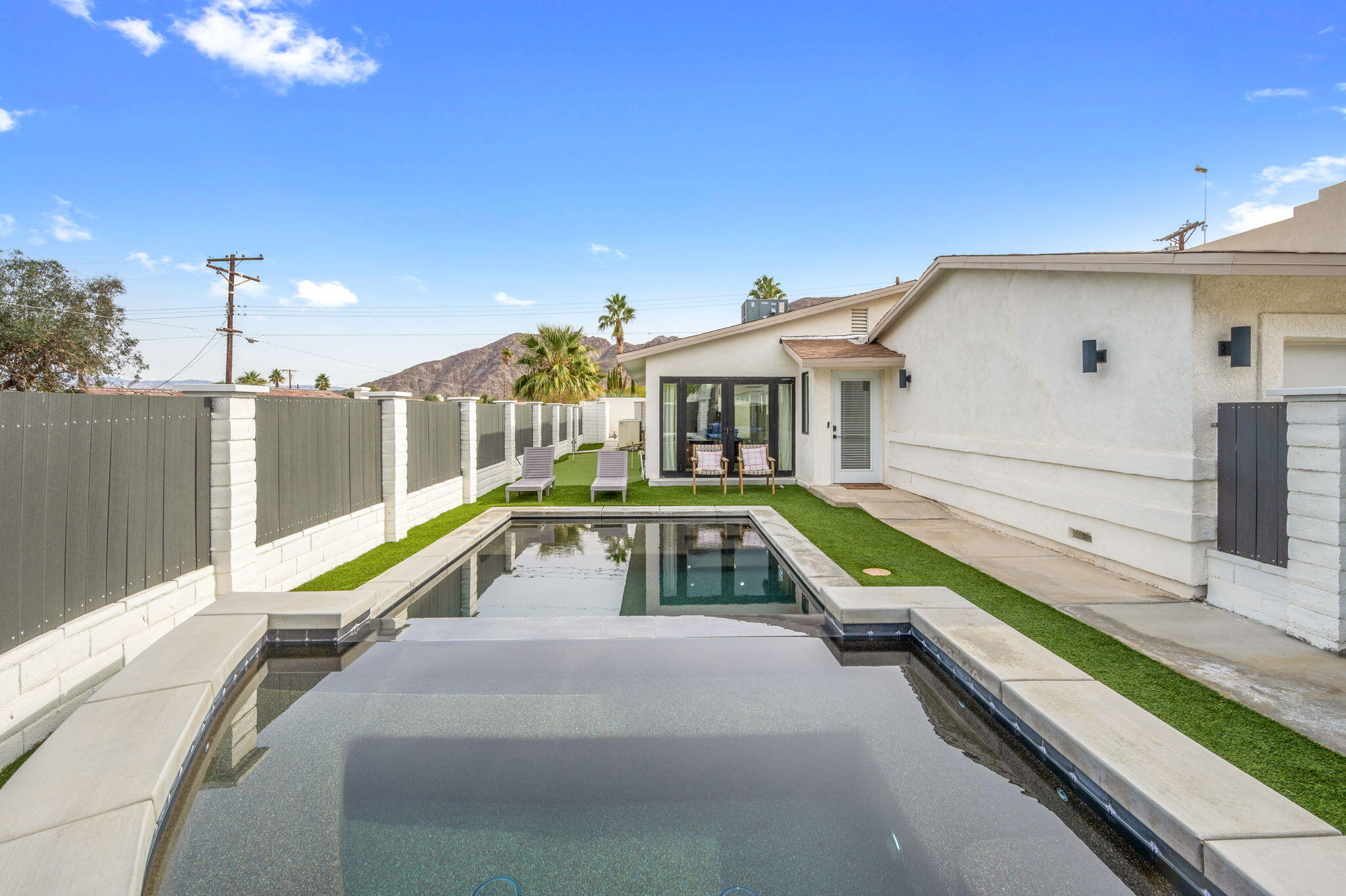 a view of swimming pool with a lounge chairs