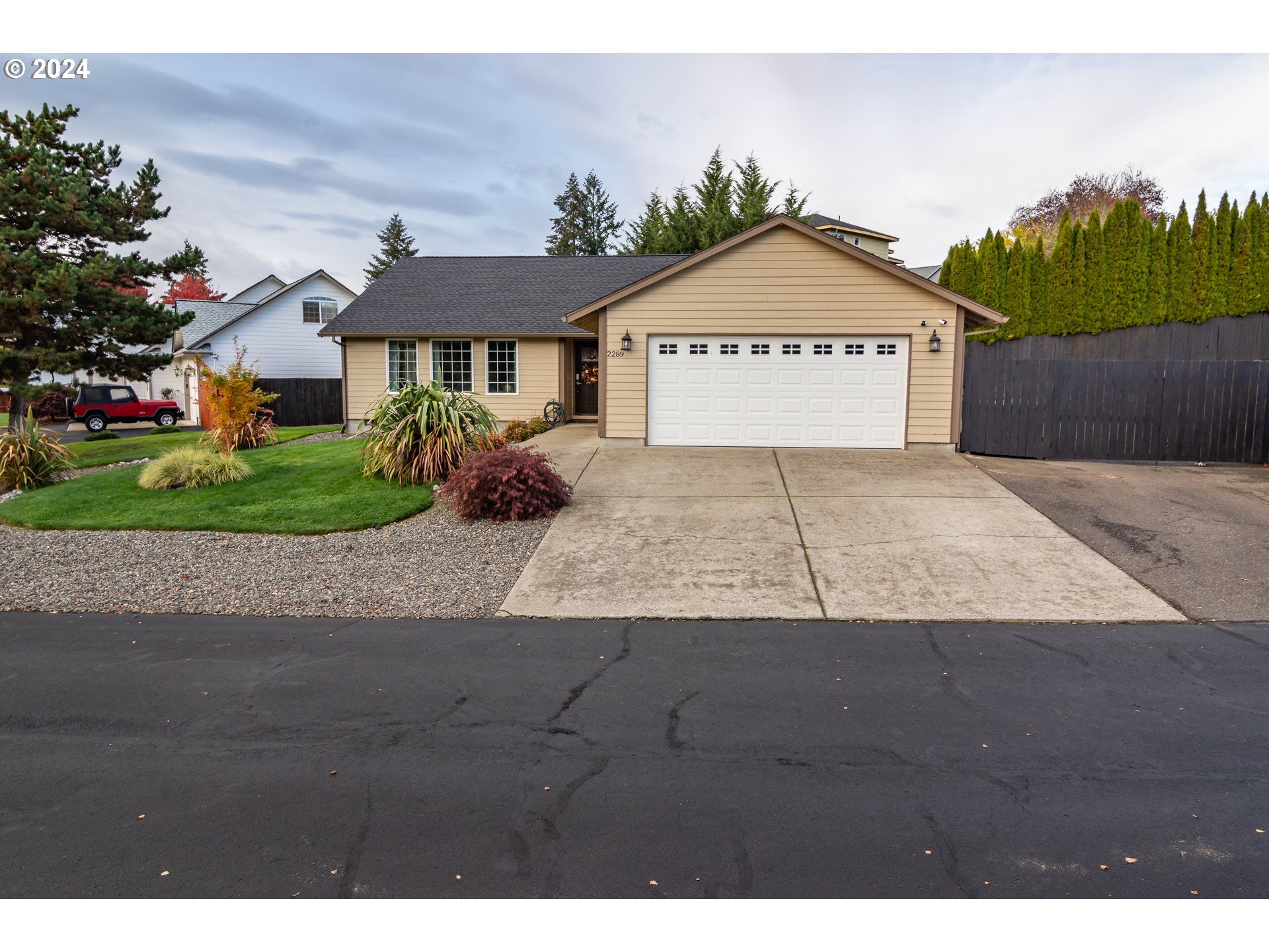 a view of a house with a yard and street