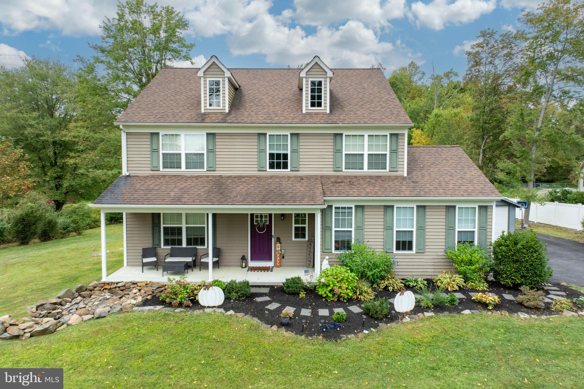 a front view of a house with a yard and potted plants