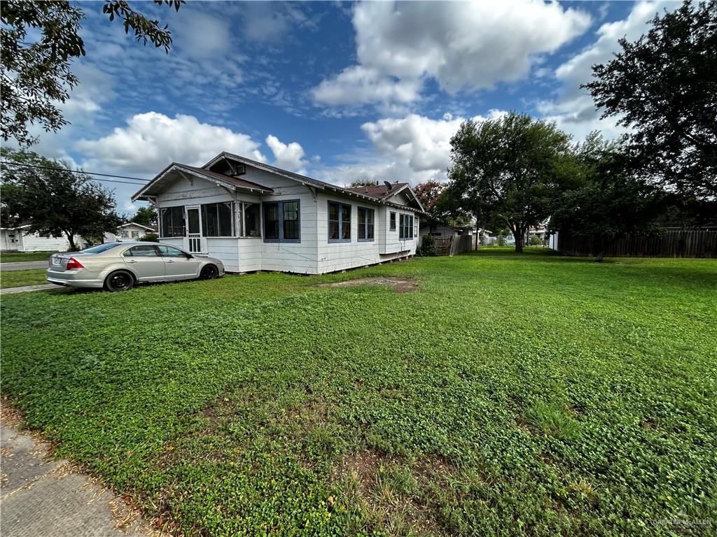 a view of a house with a big yard and large trees